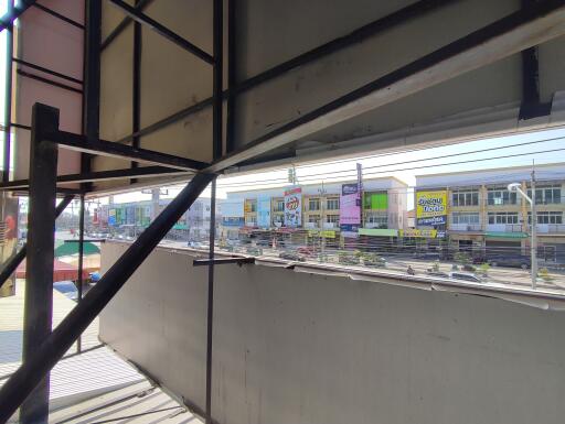 View from the balcony showing surrounding area with commercial buildings and street