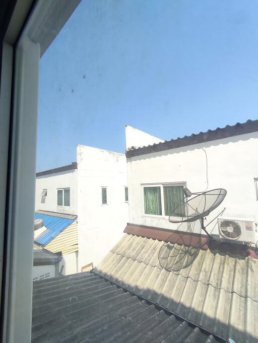 View from a residential window showing neighboring buildings and rooftops