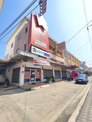 Street view of a multi-story commercial-residential building with signage