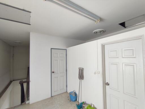 Interior view of a vacant building space with white doors and unfinished ceiling