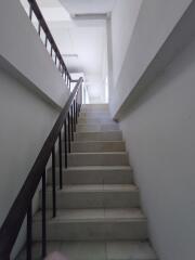 Interior staircase with white walls and steps leading up to another floor