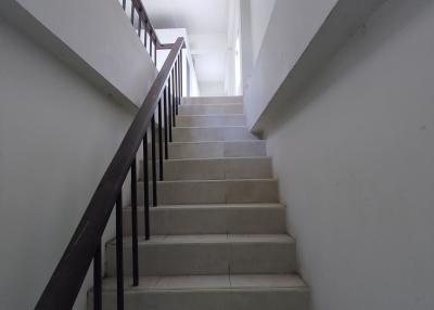 Interior staircase with white walls and steps leading up to another floor