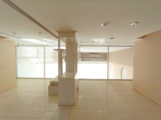 Spacious and well-lit commercial space with reflective floors and artificial lighting