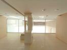 Spacious and well-lit commercial space with reflective floors and artificial lighting