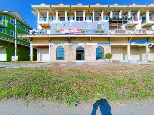 Exterior view of a multi-story residential building with commercial space on the ground floor for sale or rent