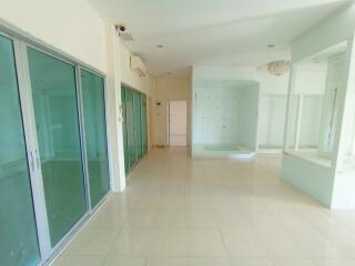 Spacious unfurnished living room with large windows and tiled flooring