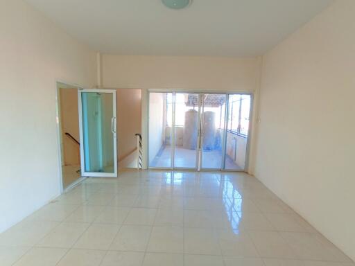 Spacious and bright empty living room with tiled flooring and large glass doors