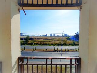 View from balcony overlooking road and open land