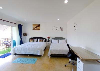 Spacious bedroom with double beds and balcony access