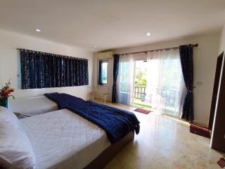 Spacious bedroom with balcony access and natural lighting