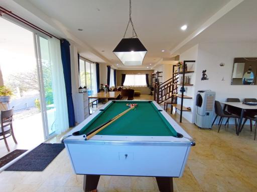 Spacious living area with pool table, large windows, and modern furnishings