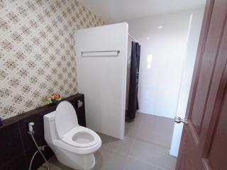 Modern bathroom with decorative wallpaper and tiled flooring