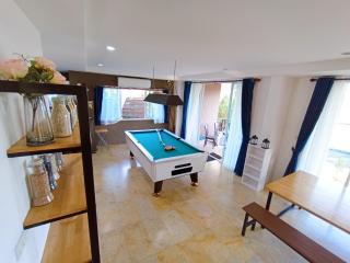 Spacious and well-lit living area with a pool table and stylish interior