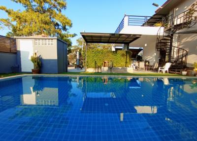 Spacious backyard with a swimming pool and shaded patio area