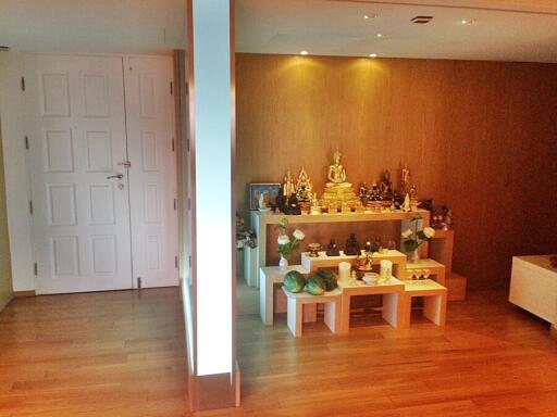 Spacious living room with wooden floors and a personal shrine