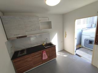 Compact kitchen with modern cabinetry and laundry area