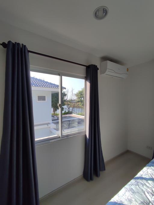 Bright bedroom with large window and air conditioning unit