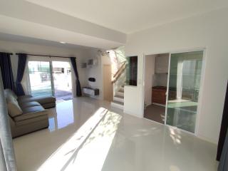 Spacious and bright living room with staircase and sliding glass doors