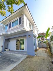 Modern two-story house with a spacious front yard and carport