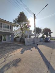 Exterior view of a residential building with a street and parked car