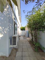 Side passage of a house with air conditioning units and a water tank