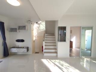 Spacious living room with natural light, staircase, and modern design