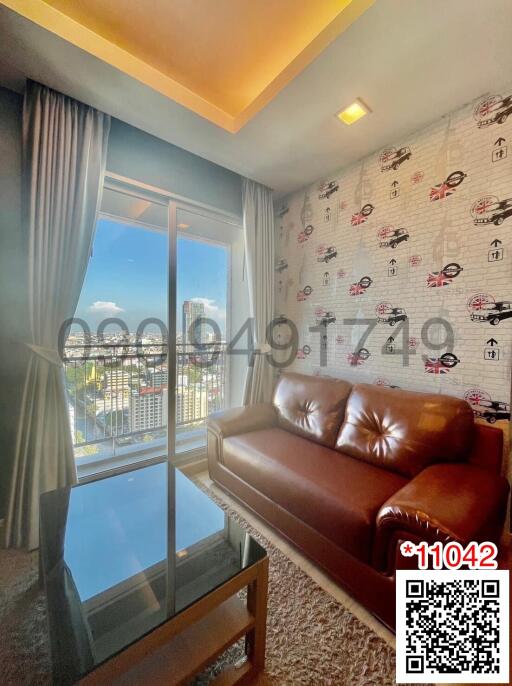 Cozy living room with a brown leather sofa and large window view