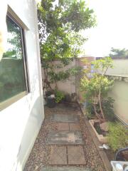 Private garden path with lush greenery next to a residential building