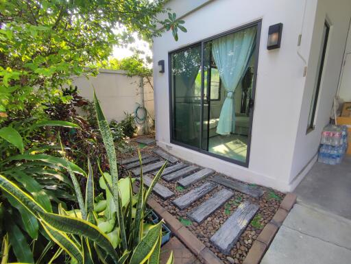 Cozy private patio with lush greenery and sliding glass doors