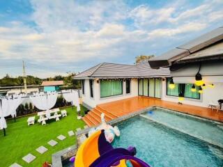 Suburban house with swimming pool and backyard at dusk