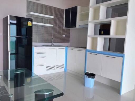 Modern kitchen with white cabinetry, built-in appliances, and glass dining table