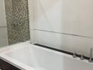 Modern bathroom with clean white bathtub and glass shower