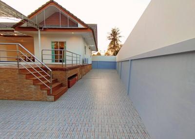 Exterior view of a two-storey house with a staircase and balcony