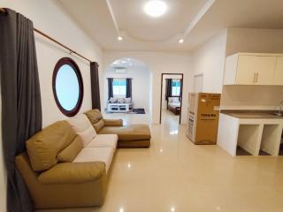 Spacious living room with modern furniture and adjacent kitchen