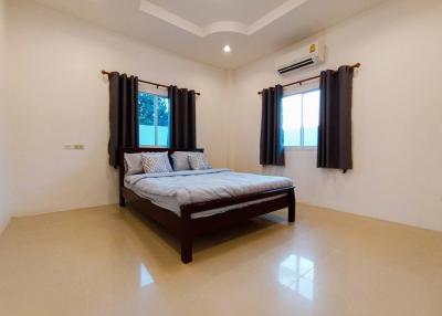 Spacious bedroom with king-sized bed and modern air conditioning unit