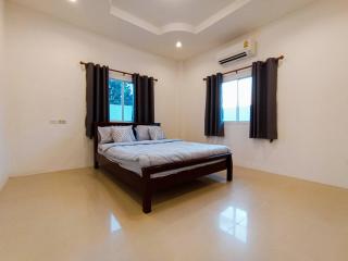 Spacious bedroom with king-sized bed and modern air conditioning unit