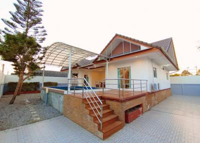 Front view of a single-story house with carport and staircase entrance