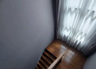 Dimly lit staircase with wooden steps and white curtains