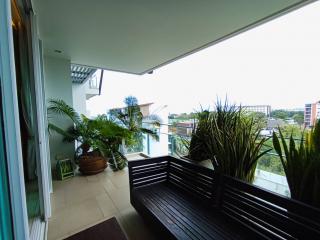 Spacious balcony with a view, featuring outdoor seating and potted plants