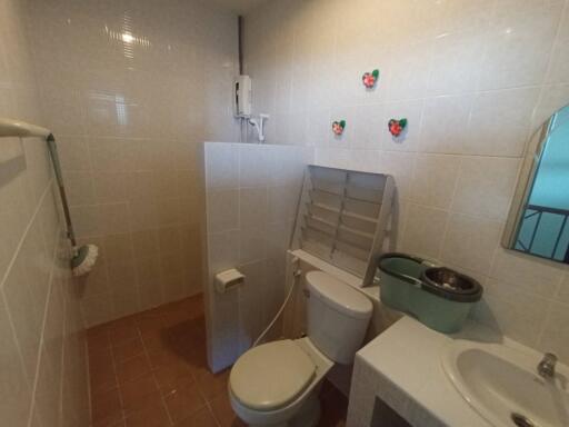 Compact bathroom with white fixtures and terracotta tiles