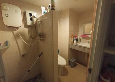 Compact bathroom with beige tiles and essential fixtures
