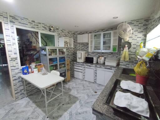 Modern kitchen with stone wall finish and fully equipped with appliances