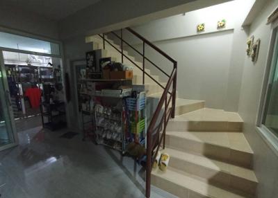 Spacious staircase area with storage shelving and tile flooring