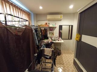 Cluttered bedroom with clothes rack and large wardrobe