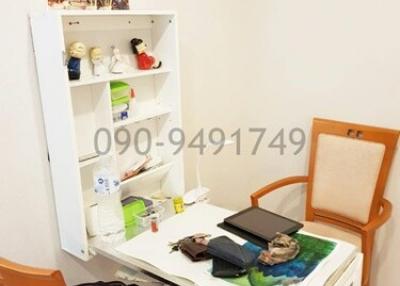 Compact home office space with open shelving and a small desk