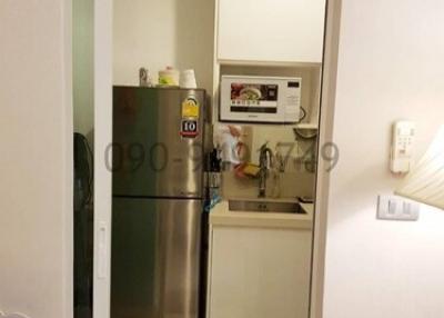 Compact kitchen with refrigerator and storage space