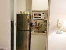 Compact kitchen with refrigerator and storage space