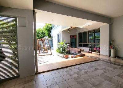 Spacious covered patio area with tiled flooring and garden access