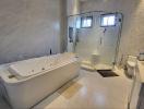 Spacious modern bathroom with bathtub and glass shower enclosure