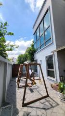 Modern two-story house exterior with spacious patio and swing